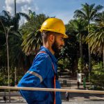 Trabalhador com capacete e uniforme de segurança durante obras de manutenção na Estação da Luz, em São Paulo.
