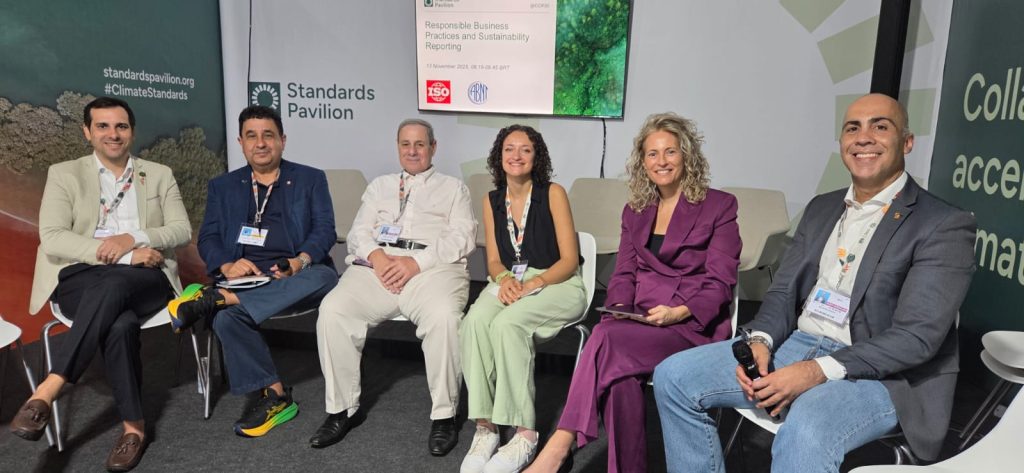 Participantes do painel da ABNT na COP30 sentados em frente ao telão que apresentou a nova norma de competências para manutenção de veículos elétricos e híbridos.