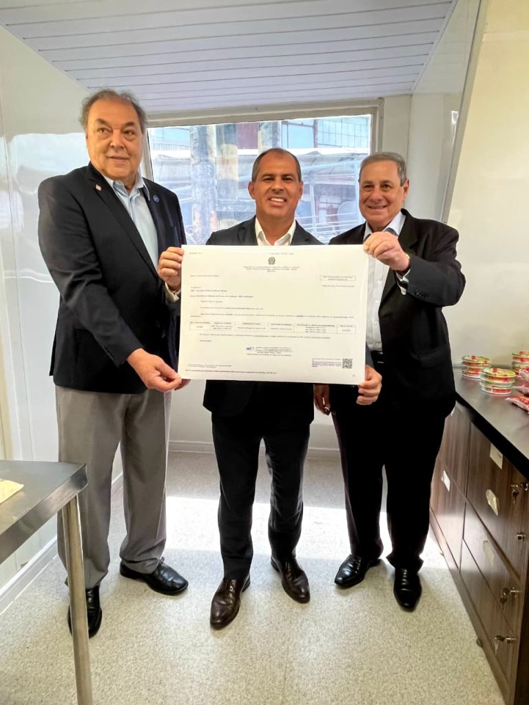 Presidentes da ABNT e do Inmetro posam segurando o certificado de acreditação para validação de projetos de carbono.