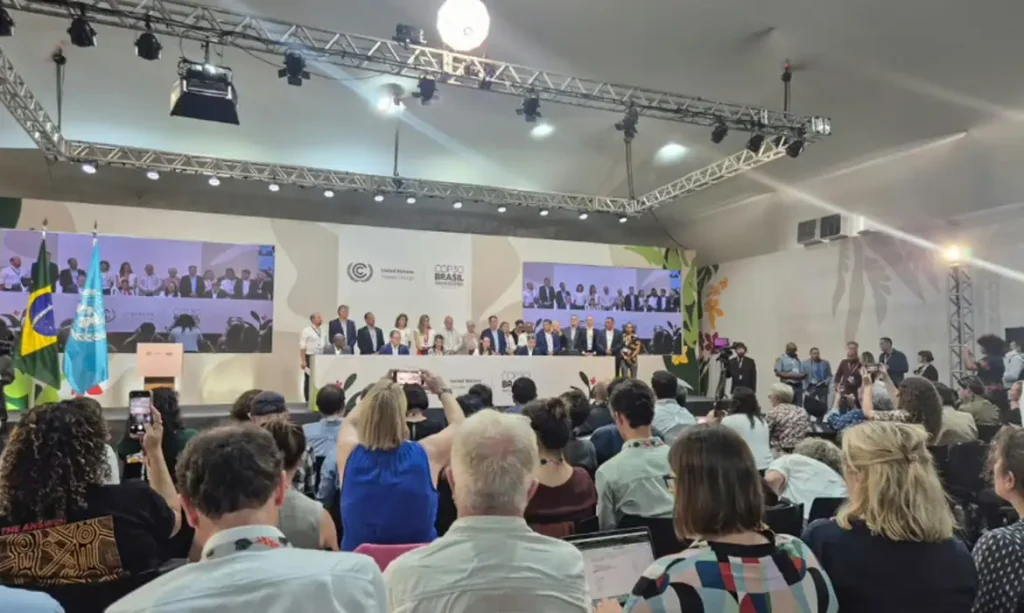 Plateia e autoridades durante evento na COP30, em Belém, com representantes de diversos países reunidos no palco.