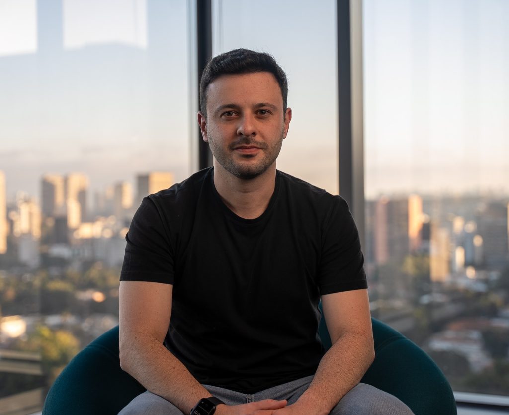 Matheus Pagani, presidente da Ploomes, em retrato com vista da cidade ao fundo.