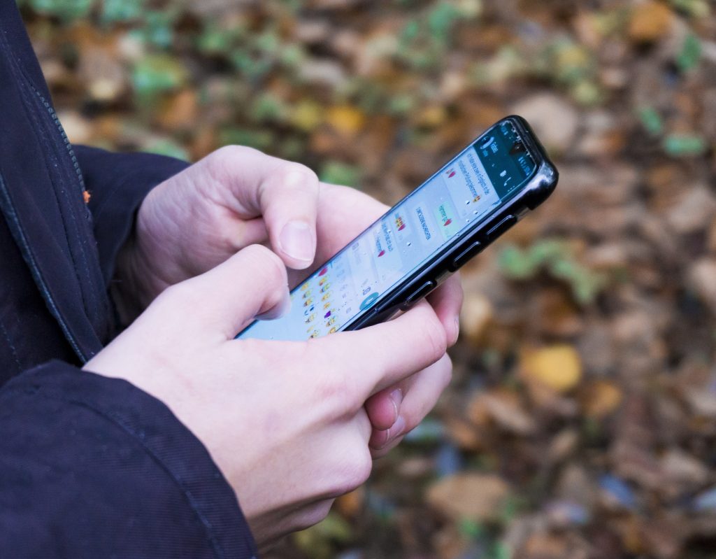 Pessoa segura smartphone com aplicativo de mensagens aberto