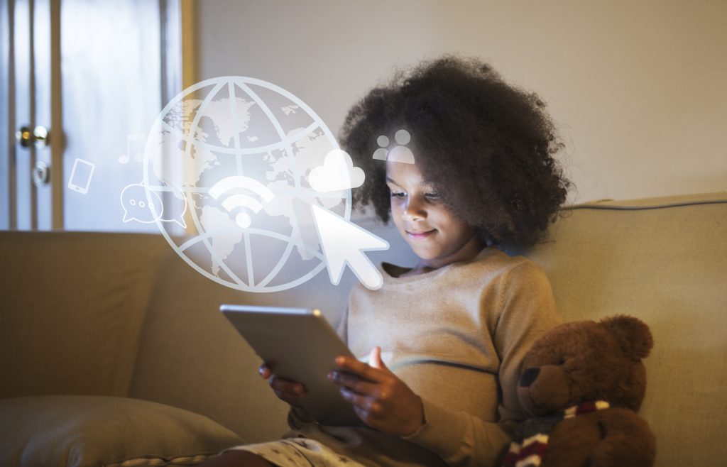 Criança usa tablet em ambiente doméstico cercada de ícones de conectividade digital